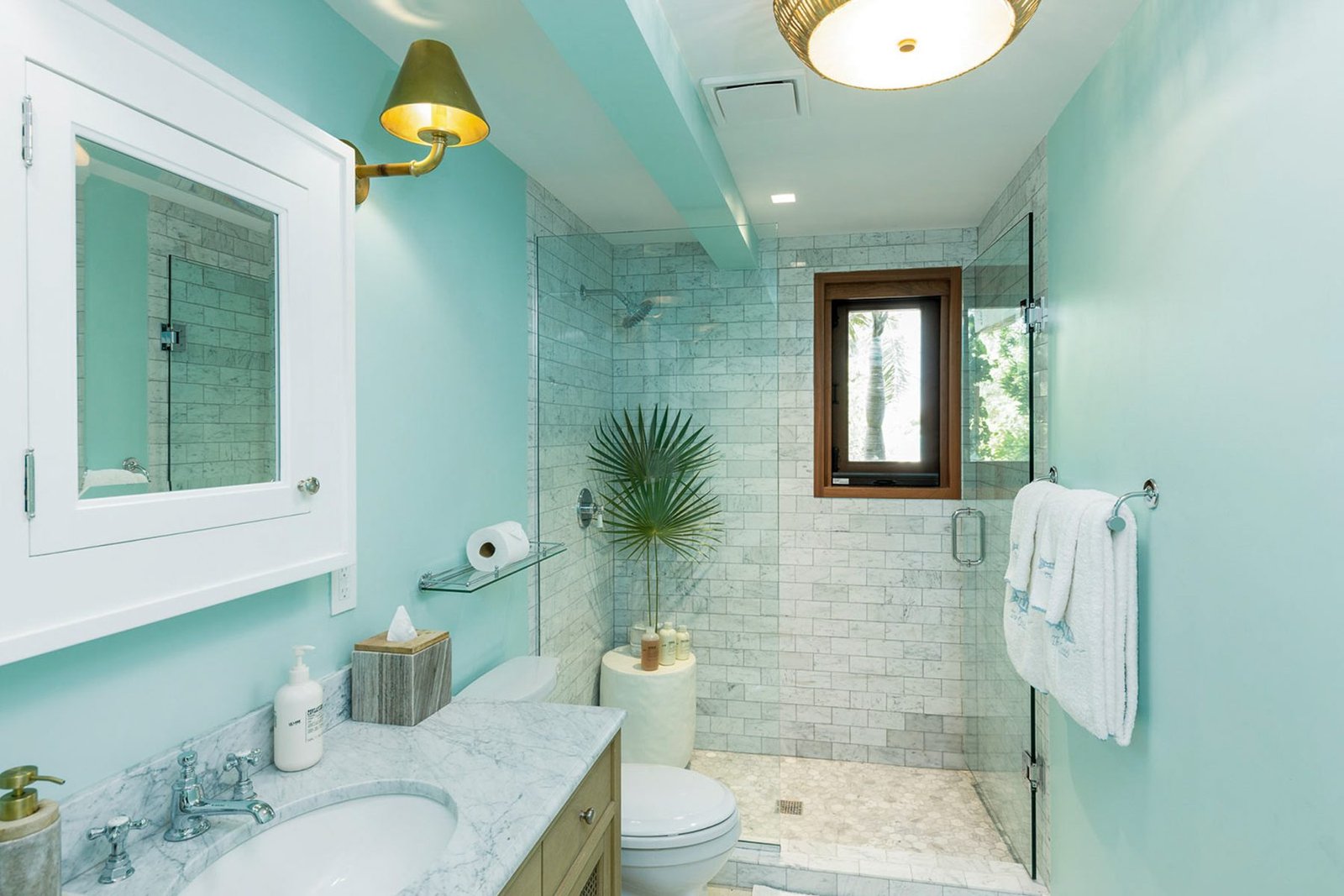 A second bathroom, marble tile and aqua walls