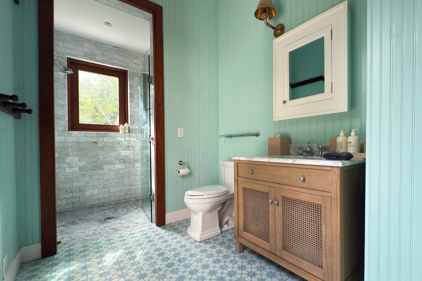 A guest bathroom with patterned tile floor and walk-in shower