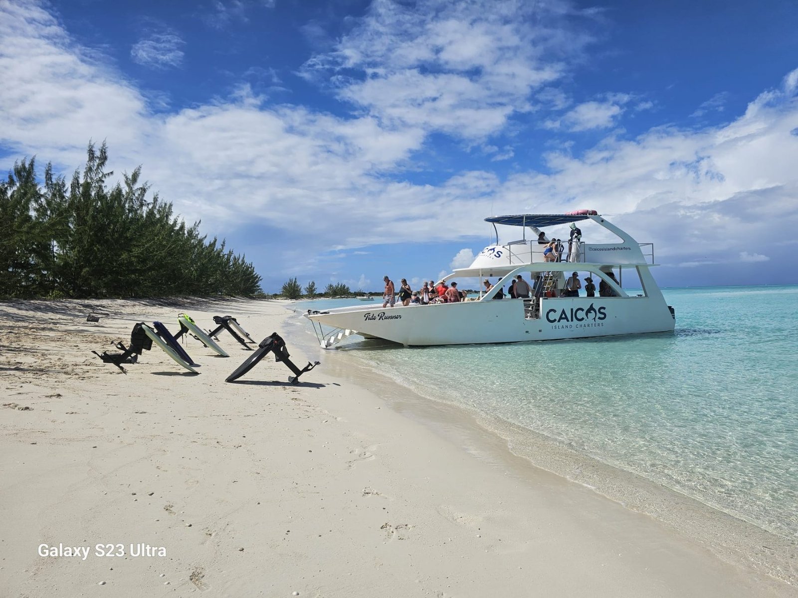 The charter catamaran on the beach beside the boards